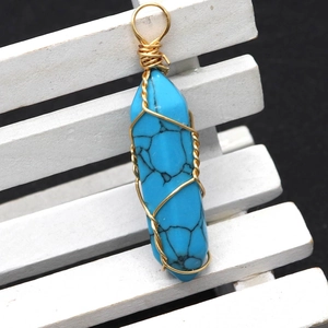 Close-up of hexagonal turquoise stone pendant with golden wire wrap craftsmanship