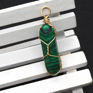 Macro detail of malachite style hexagonal pendant with gold wire wrap and hook