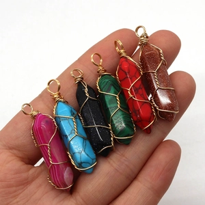 Set of 6 hexagonal wire wrapped crystal pendants held in hand with assorted natural stones