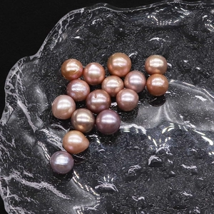 Macro shot of colorful high luster Edison freshwater pearls in a rippled glass tray