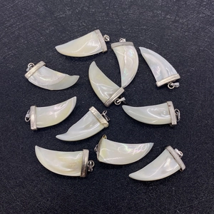 Pendentifs en nacre naturelle en forme de corne avec fermoirs argentés sur noir