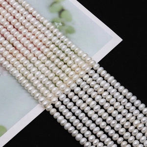 Dettaglio macro di fili di perle d'acqua dolce bianche lucide per creazione gioielli DIY