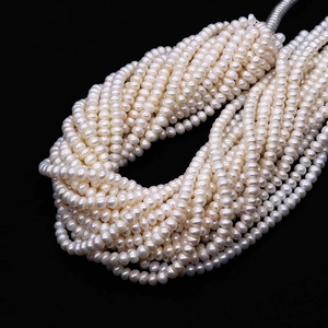 Dettaglio macro di fili di perle naturali d'acqua dolce bianche su fondo nero