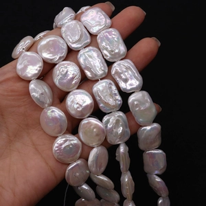 Macro view of genuine baroque freshwater pearls with high luster in hand on black backdrop