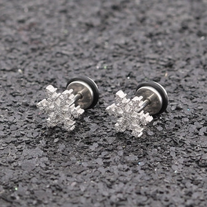 Gros plan de boucles d'oreilles flocon avec cristaux blancs et anneaux en caoutchouc noir