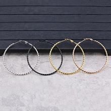 Detailansicht von vier Paar großen gedrehten Creolen in Gold, Silber, Schwarz und Roségold-Optik