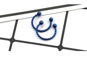Macro detail of blue twisted rope stainless steel horseshoe rings for body piercing