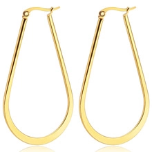 Detailansicht großer goldener Tropfenohrringe mit polierter flacher Metalloberfläche