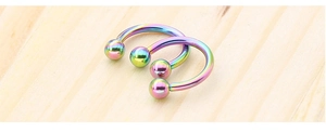 Detailed macro of rainbow finish stainless steel horseshoe rings with double ball ends