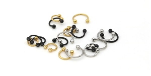 Macro view of stainless steel circular barbells in gold, silver and black metal finishes