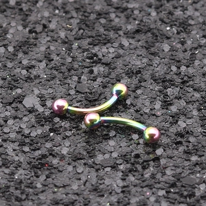 Piercings de sourcil courbés en acier inoxydable arc-en-ciel sur fond de pierre noire