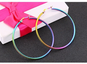 Detail der Regenbogen-Creolen auf einer Geschenkbox mit Schleife und sicherem Verschluss