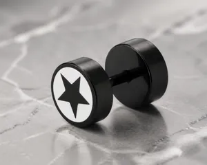 Detalle de pendiente tipo pesa en negro mate con patrón de estrella de pentagrama blanco