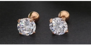 Vue macro des boucles d'oreilles en or rose à vis avec zircons ronds à quatre griffes
