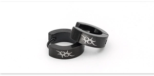 Detail of black stainless steel hoop earrings with silver tribal totem engravings