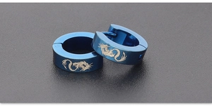 Macro shot of dark blue stainless steel ear clips with detailed engraved dragon pattern