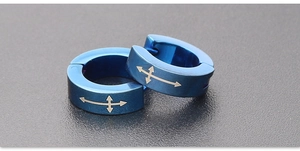 Macro view of blue stainless steel hoop earring featuring an engraved cross arrow pattern