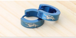 Close-up of blue stainless steel hoop earrings with tribal wing laser engraving