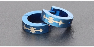Macro shot of blue titanium steel hoop earrings featuring yellow star geometric patterns