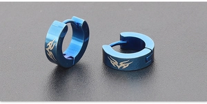 Detailed close-up of blue titanium steel earrings with silver tribal pattern engraving