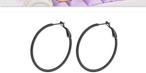 Detail view of large matte black titanium hoop earrings with secure click closure