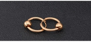 Macro shot of rose gold hoop earrings featuring polished metal beads on black texture