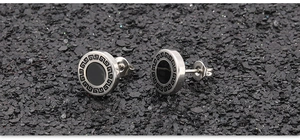 Detail van ronde punk oorbellen met Grieks patroon en zwarte inleg op donker vlak