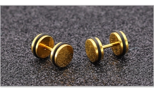 Detail van gouden halter oorknopjes met zwarte rubberen ringen op een matte achtergrond