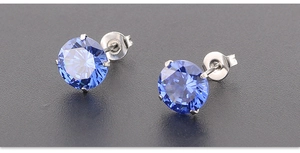 Detail of 7mm blue AAA zircon stud earrings with four-prong silver titanium setting