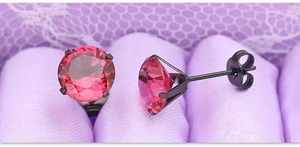 Detailed macro view of 8mm pink zircon studs with black four-prong stainless steel setting