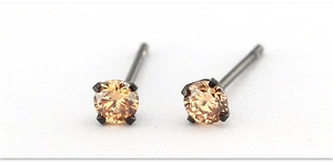 Vista macro di uno zircone champagne da 4mm incastonato in un orecchino in acciaio nero