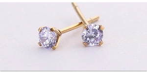 Dettaglio di orecchini a lobo con zircone viola 4 mm e montatura a quattro griffe