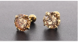 Macro detail van vergulde 7mm champagne zirconia oorbellen met vierklauw zetting