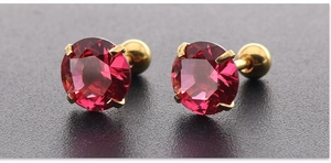 Macro-opname van 7mm rode zirkoon oorbellen met gouden vier-potige zetting en schroefsluiting