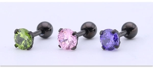 Detalle de tres pendientes de acero de titanio negro con piedras de circonita de colores