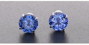 Detail van blauwe zirkoon oorknopjes met 4-klauwszetting in roestvrij staal materiaal