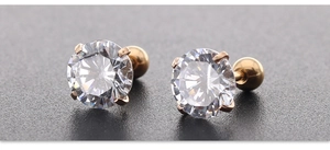 Macro-opname van 6mm zirkoon oorbellen met gouden pootjes en veilige schroefsluiting