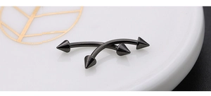 Close-up of black 316L stainless steel curved barbell jewelry with sharp spike ends