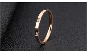 Detail of rose gold stainless steel ring featuring tiered texture and three zircon stones