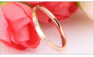 Detail shot of rose gold titanium ring with zircon inlays on a soft floral background