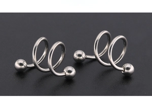 Macro shot of silver titanium steel spiral eyebrow rings with solid ball ends on black