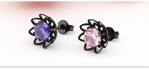 Makroaufnahme von Titanstahl-Rosenohrringen mit lila und rosa Zirkonia-Steinen
