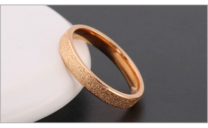 Detailed close-up of rose gold stainless steel ring with matte and polished dual texture