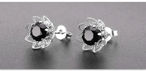 Detail von blumenförmigen Ohrsteckern mit rundem schwarzem Zirkon und Silber-Finish