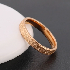 Elegant rose gold frosted stainless steel ring displayed on a minimalist stone base