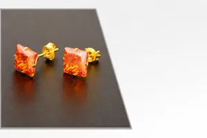 Detalle de pendientes de circonita roja cuadrada con baño de oro de 14 quilates
