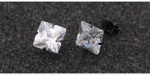Vista macro de pendientes de circonita cuadrada con engaste negro de cuatro garras