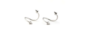 Gros plan sur des anneaux de piercing spirales en S en acier poli avec pointes punk