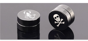 Primer plano de pendientes magnéticos negros con diseños de escorpión y calavera