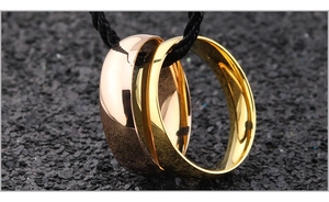 Polished gold and rose gold titanium steel rings interlocked on a black braided cord